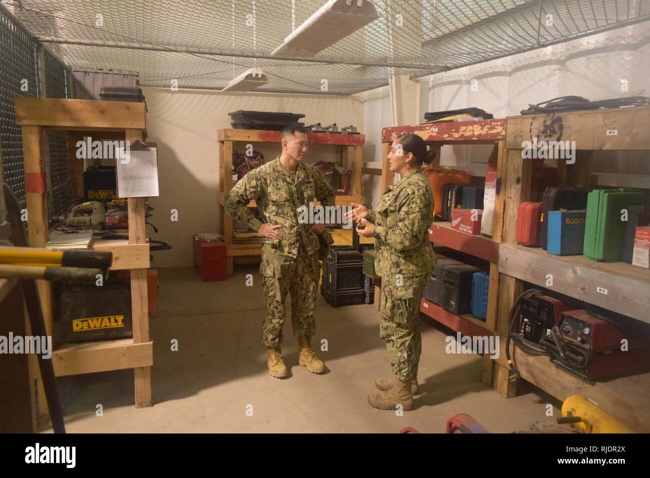 DIEGO GARCIA, British Indian Ocean Territory (Jan. 16, 2018) Commanding  Officer of Naval Mobile Construction Battalion 4 Cmdr. James Cho (left)  receives a brief from Builder 3rd Class Veronica Prado on how