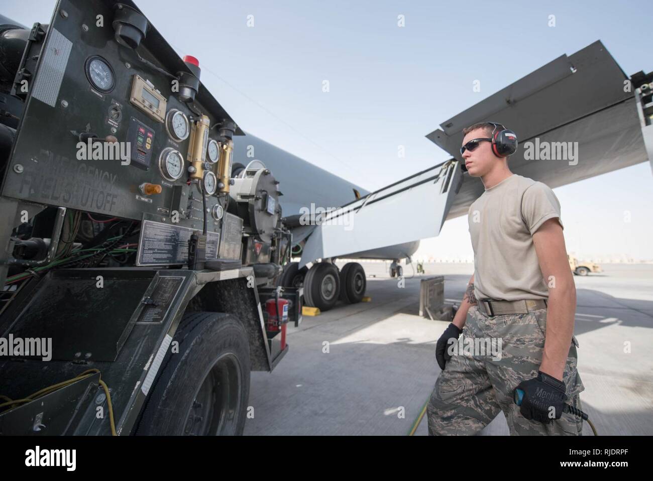 U.S. Air Force Airman Austin Collings, fuels distribution specialist assigned to the 379th Expeditionary Logistics Readiness Squadron, watches  gauges as he refuels a KC-135 Stratotanker at Al Udeid Air Base, Qatar, Jan. 23, 2018. Collings is using an R-12 fuel truck to fuel the KC-135 that is assigned to the 340th Expeditionary Air Refueling Squadron , which is responsible for delivering two-thirds of all fuel to airborne receivers in the U.S. Central Command’s area of responsibility. Stock Photo