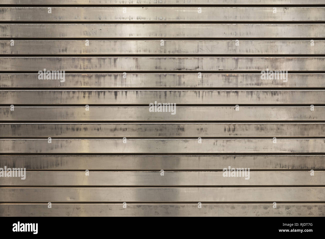grunge scratched and stained metal roll up door background with horizontal slats Stock Photo