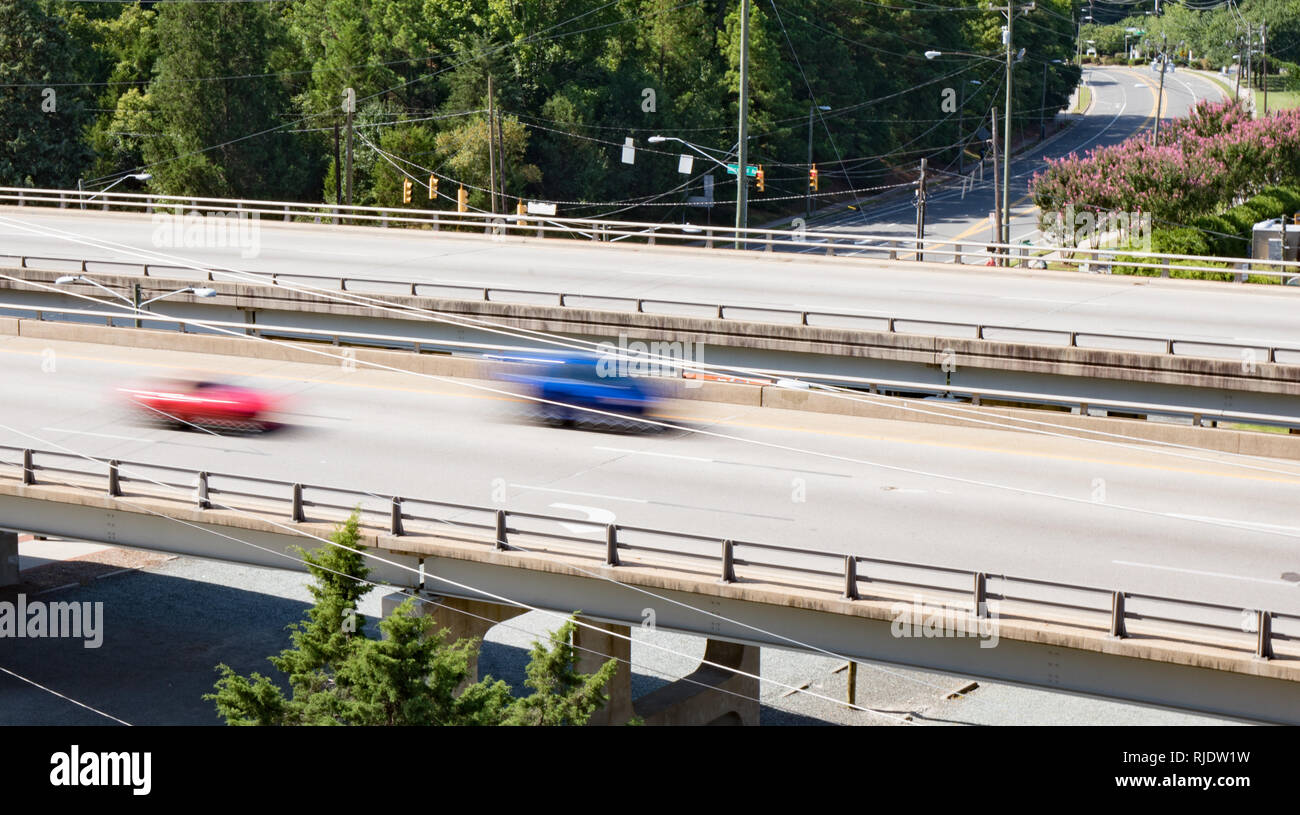Two vehicles crossing over a bridge taken with slow shutter speed to show movement and speed. Stock Photo