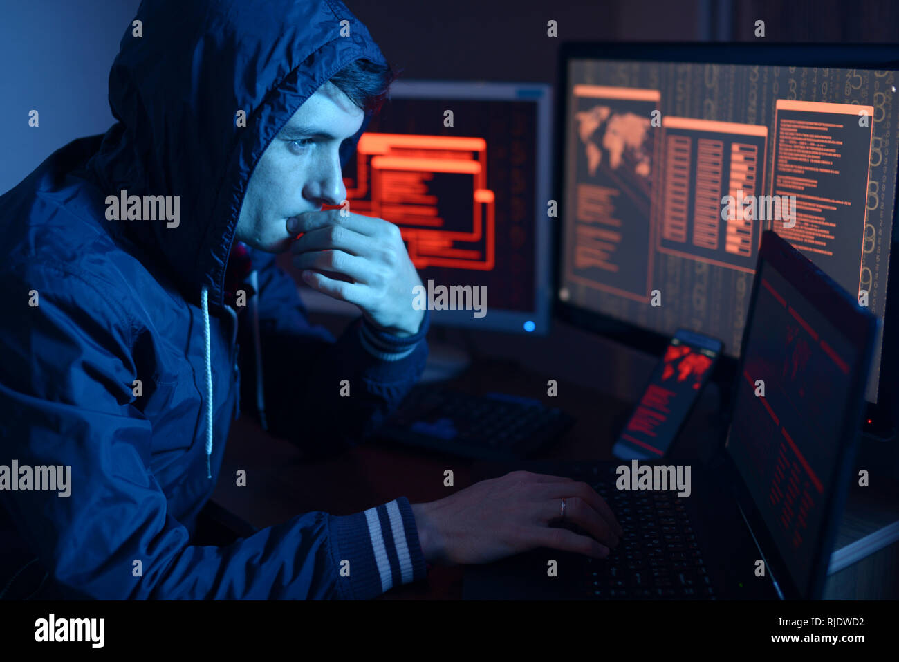 Hacker in a hood thinking about the problem of hacking or malware ...