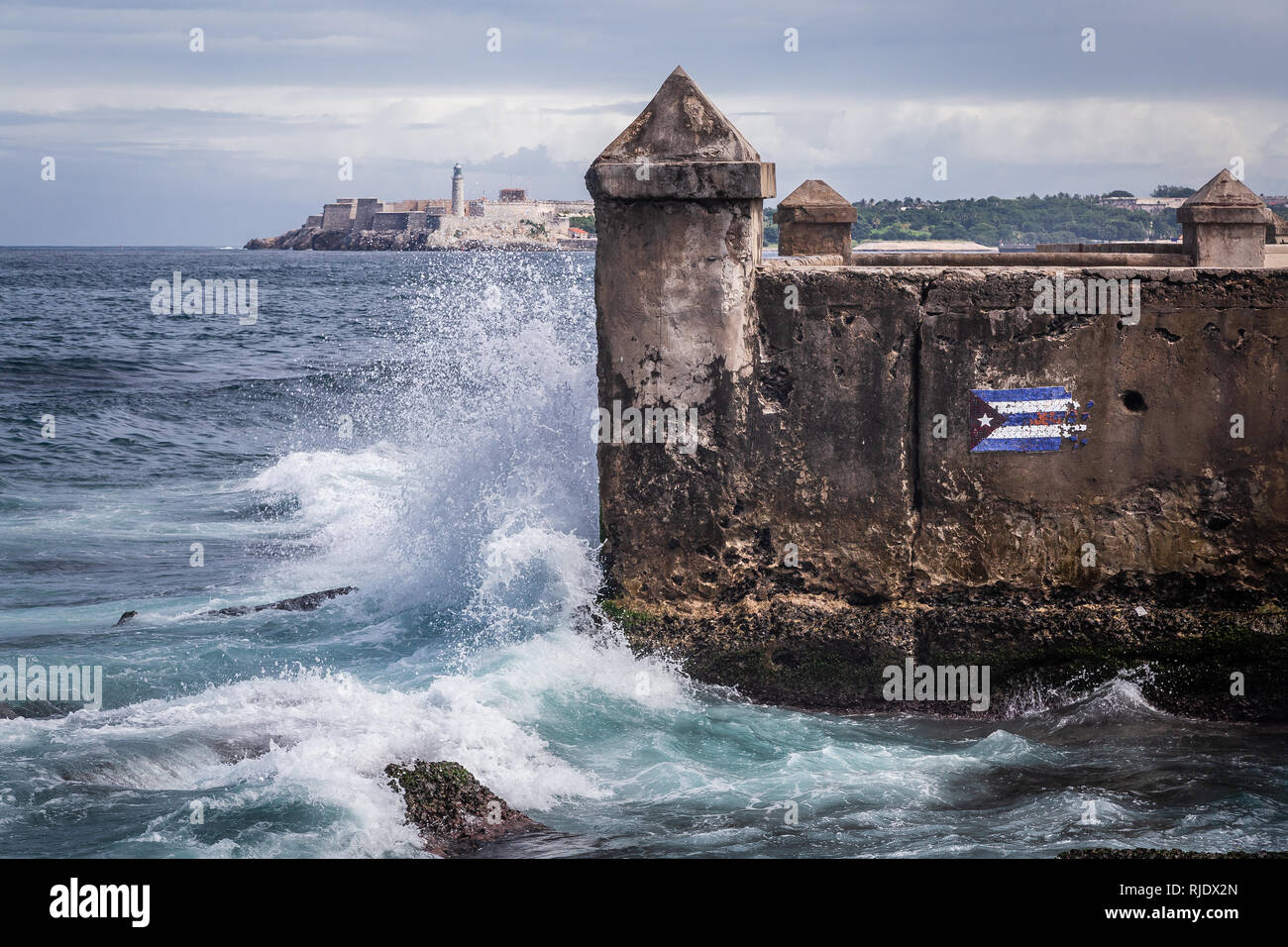 Cuba, Havana. Fortress wall and Cuban flag at San Carlos de