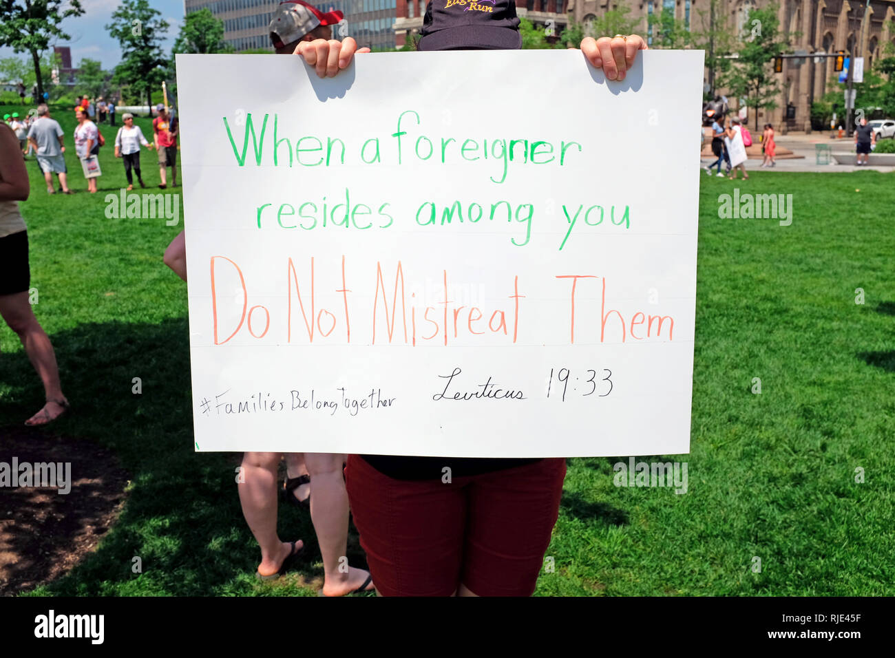 Leviticus 19:33 written on a placard at a Cleveland, Ohio rally against Trump Administration immigration policies is held up by a protester. Stock Photo