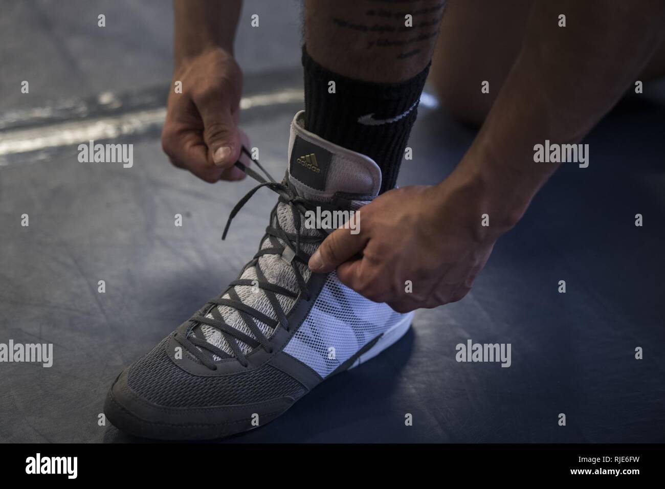 Airman 1st Class Raul Veliz, U.S. Air Force Wrestling Team member, laces up his wrestling shoes prior to practice at Joint Base McGuire-Dix-Lakehurst, N.J., Jan. 2018. The Air Force Wrestling Team has been training for the Armed Forces Wrestling Championship at Marine Corps Base Camp Lejeune, N.C. ( U.S. Air Force Stock Photo