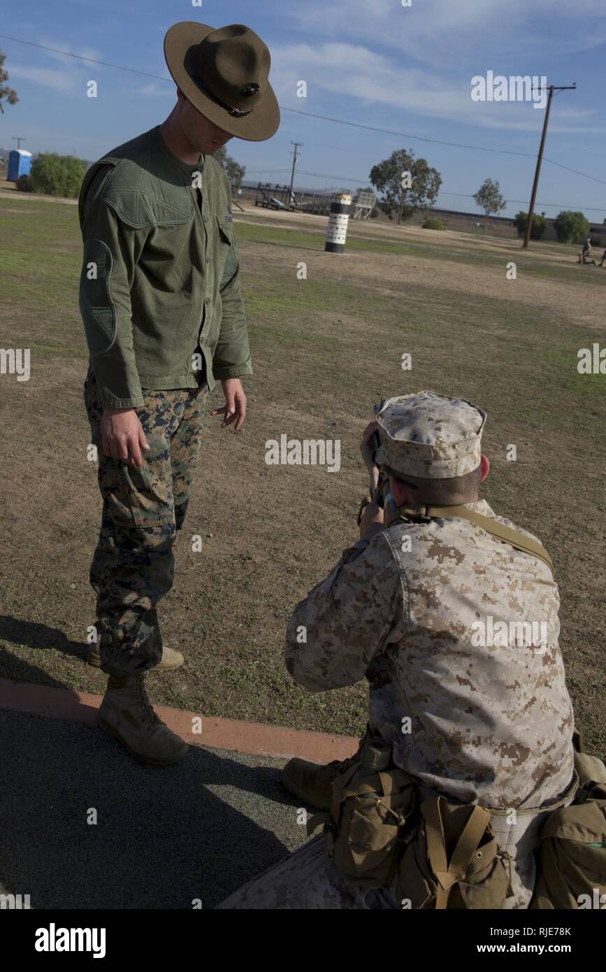 A primary marksmanship instructor with Edson Range, Weapons and Field Training Battalion, assists a recruit from Mike Company, 3rd Recruit Training Battalion, with his sitting position during grass week at Marine Corps Base Camp Pendleton, Calif., Jan. 17. The PMIs corrected the recruits’ shooting positions to improve their ability to accurately fire their weapons for qualification. Annually, more than 17,000 males recruited from the Western Recruiting Region are trained at MCRD San Diego. Mike Company is scheduled to graduate Feb. 23. Stock Photo