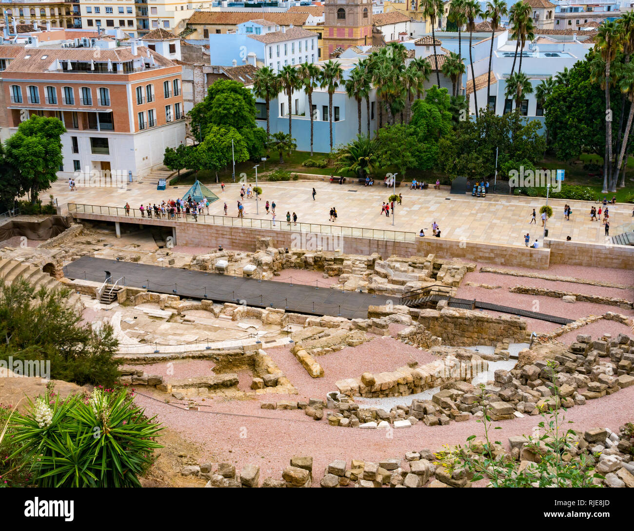Tourists on plaza of Calle Alcazabilla , with ruins of Roman Theatre, Malaga, Andalusia, Spain Stock Photo