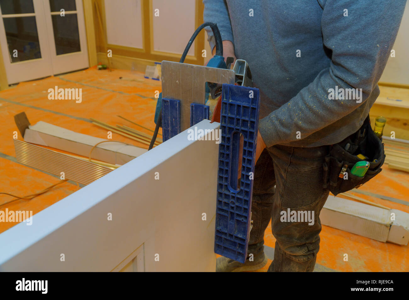 Carpenter working on an electric saw cutting wood door, repair and
