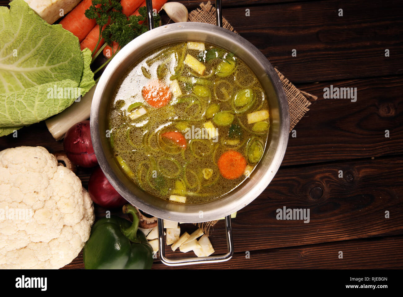 https://c8.alamy.com/comp/RJEBGN/broth-with-carrots-onions-various-fresh-vegetables-in-a-pot-colorful-fresh-clear-spring-soup-rural-kitchen-scenery-vegetarian-bouillon-RJEBGN.jpg