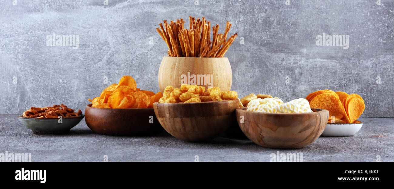 Salty snacks. Pretzels, chips, crackers in wooden bowls. Unhealthy