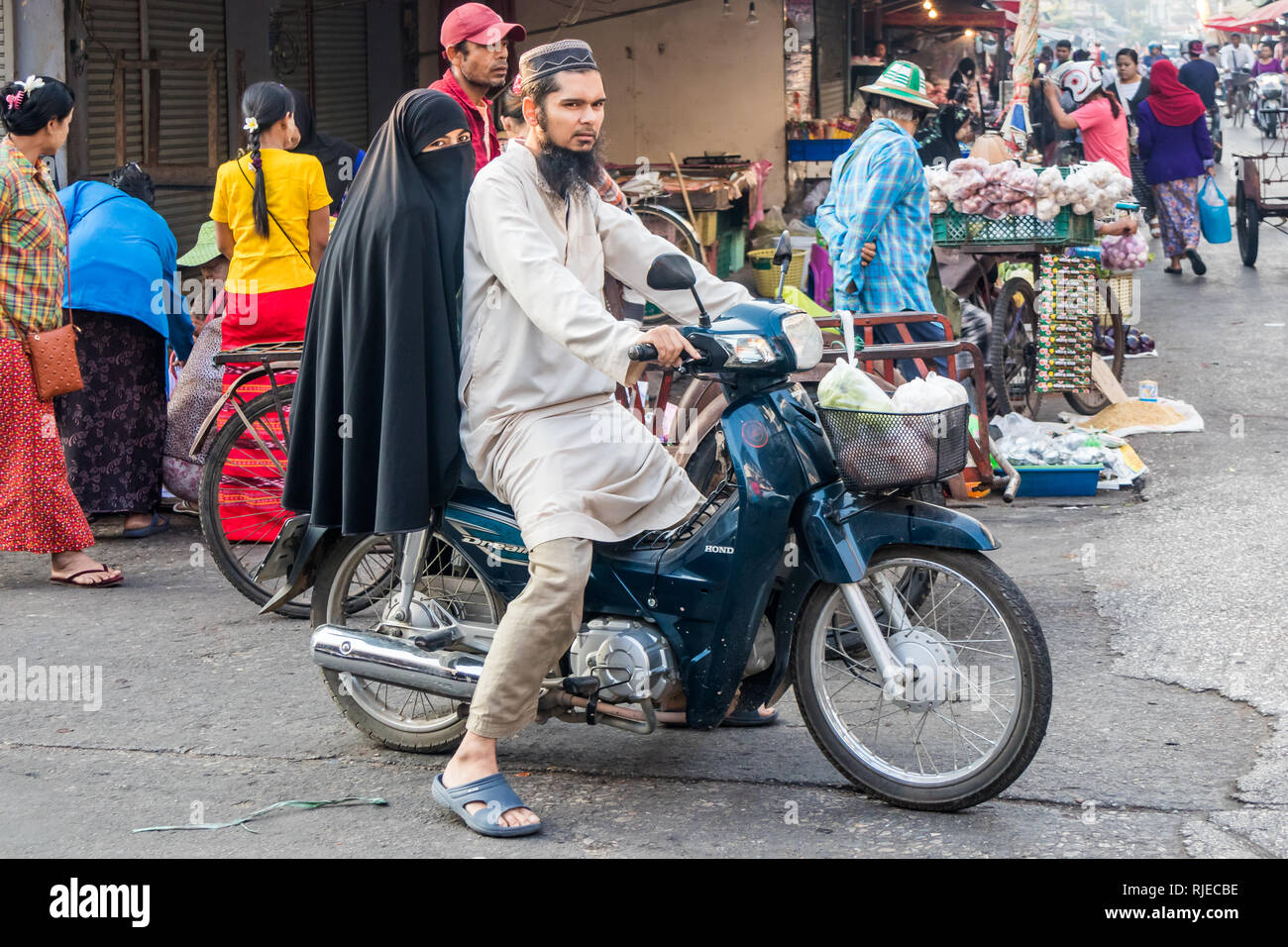 Mae Sot, Thailand - 3rd February 2019:  Muslim man and wife on motorbike. There are any ethnic groups in the towm. Stock Photo