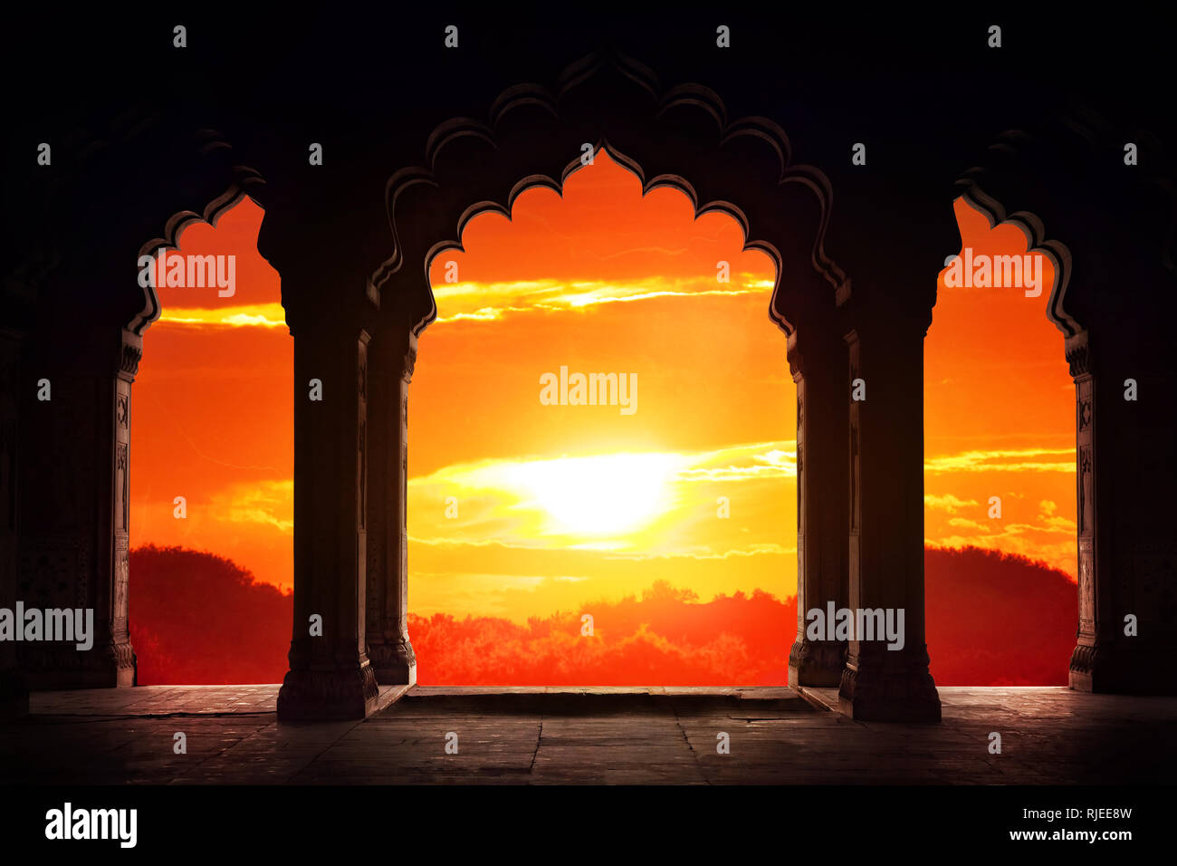 Indian arch silhouette in old temple at dramatic orange sunset sky background. Free space for text Stock Photo