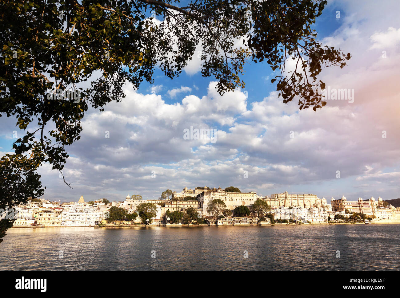 Lake Pichola with City Palace view at cloudy sunset sky in Udaipur, Rajasthan, India Stock Photo