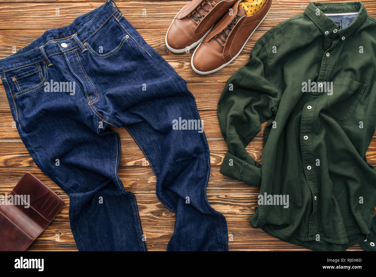 Top view of jeans, brown shoes and green shirt on wooden background Stock  Photo - Alamy