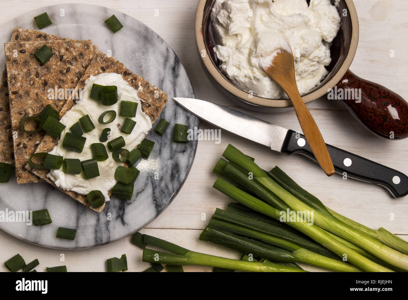 healthy, vegetarian breakfast with crispbread, quark and fresh spring onion on marble Stock Photo