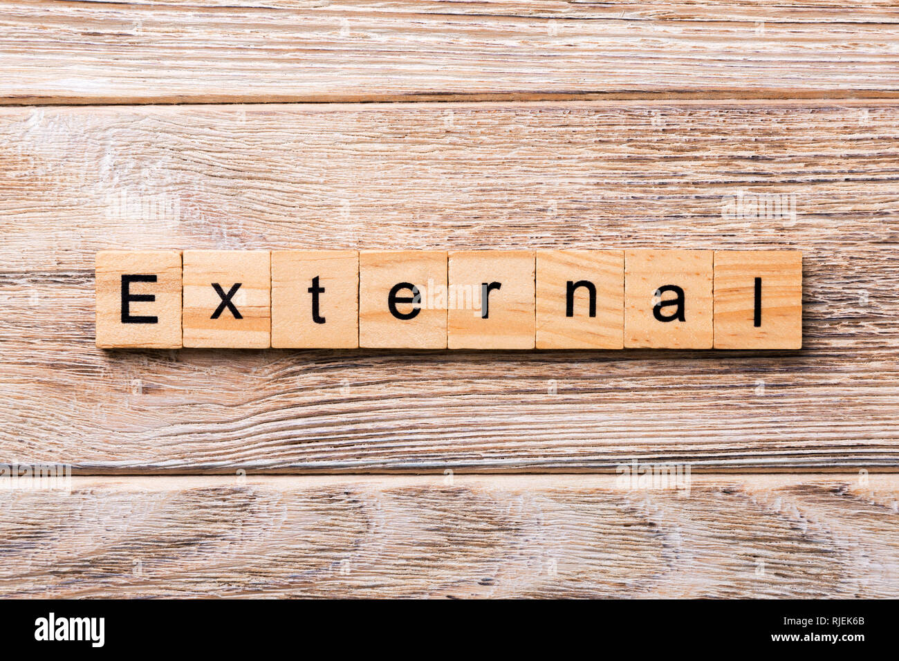 EXTERNAL word written on wood block. EXTERNAL text on wooden table for ...