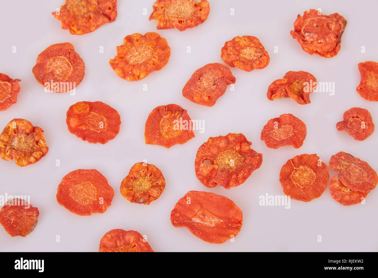 Dried carrots chips (slices) on white background. Flat lay. Stock Photo