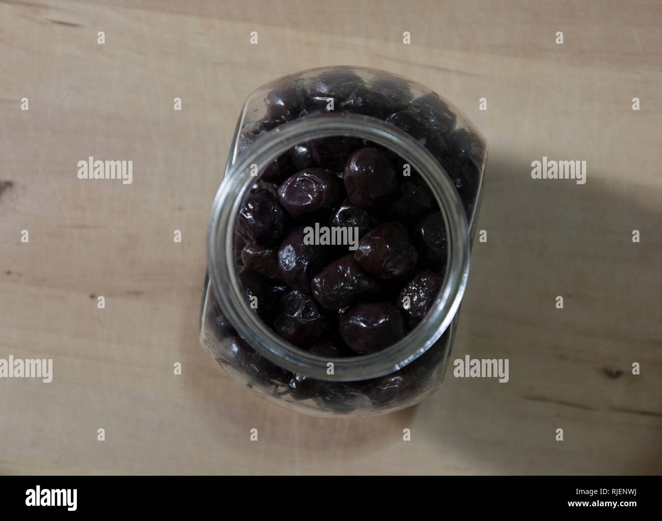 Glass jar of olives on wood, black olives Stock Photo