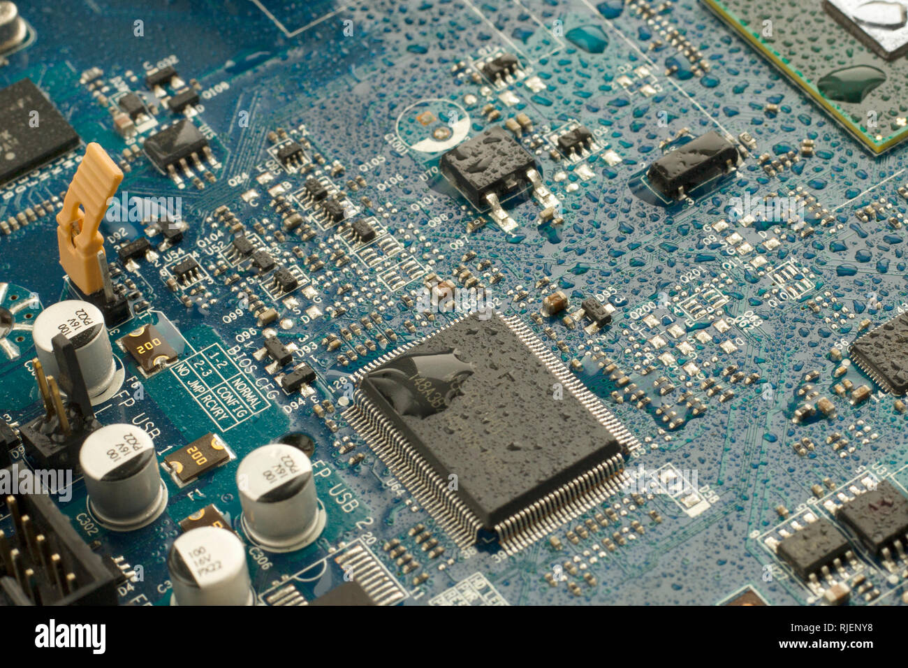 Computer part of the electrical circuit motherboard covered with water droplets. Close up image Stock Photo