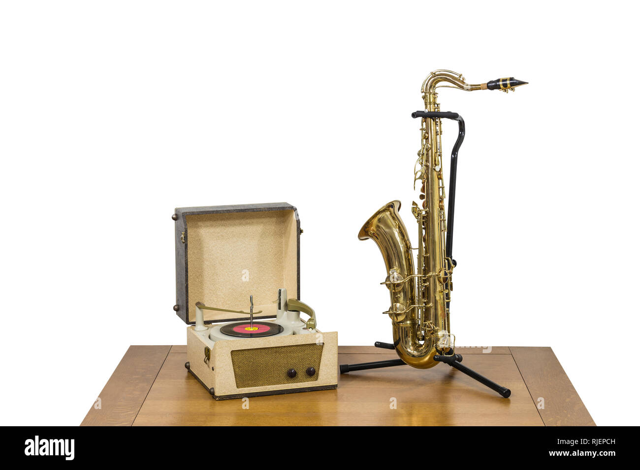 Old record player and saxophone on wood table isolated on white. Stock Photo