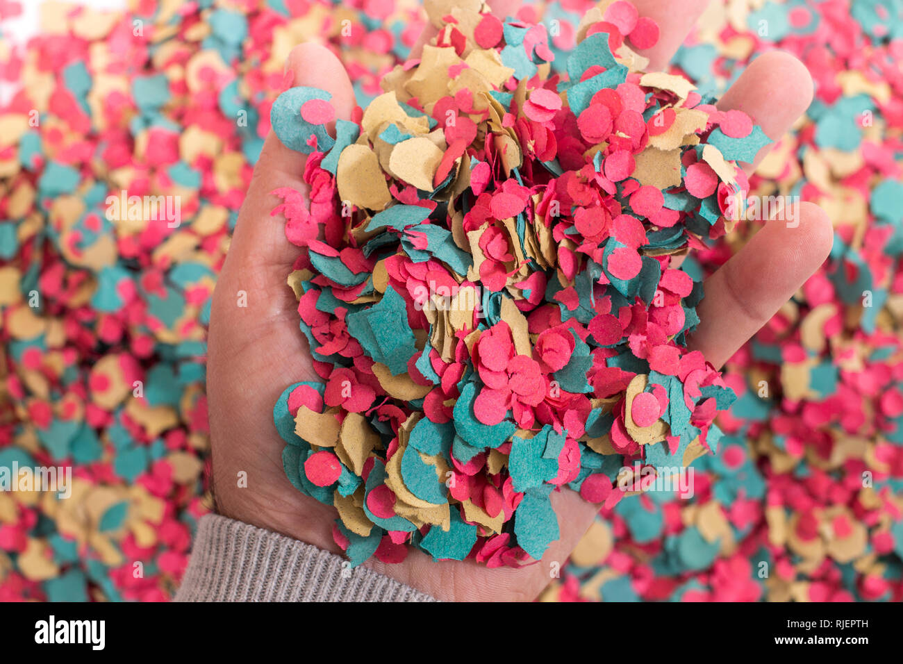 Hand grabs a mix of colorful confetti Stock Photo - Alamy