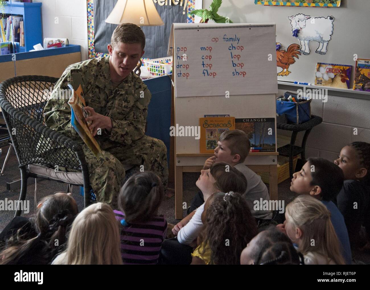 MOYOCK, N.C. (Feb. 25, 2013) Lt. Keith Caton, assigned to Explosive Ordnance Disposal Mobile Unit (EODMU) 2, reads a book during a visit to Central Elementary School. Sailors from EODMU 2 became pen pals with the students during a deployment as part of a community outreach program and agreed to visit the class upon their return to answer questions, read stories and demonstrate the PackBot transportable robotic system as well as attend a luncheon held in their honor. Stock Photo