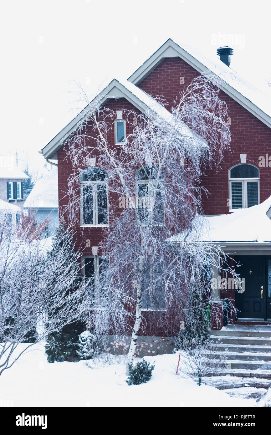 Montreal, Quebec, Canada, February 2019 - Brick House in Winter and trees after an ice storm Stock Photo