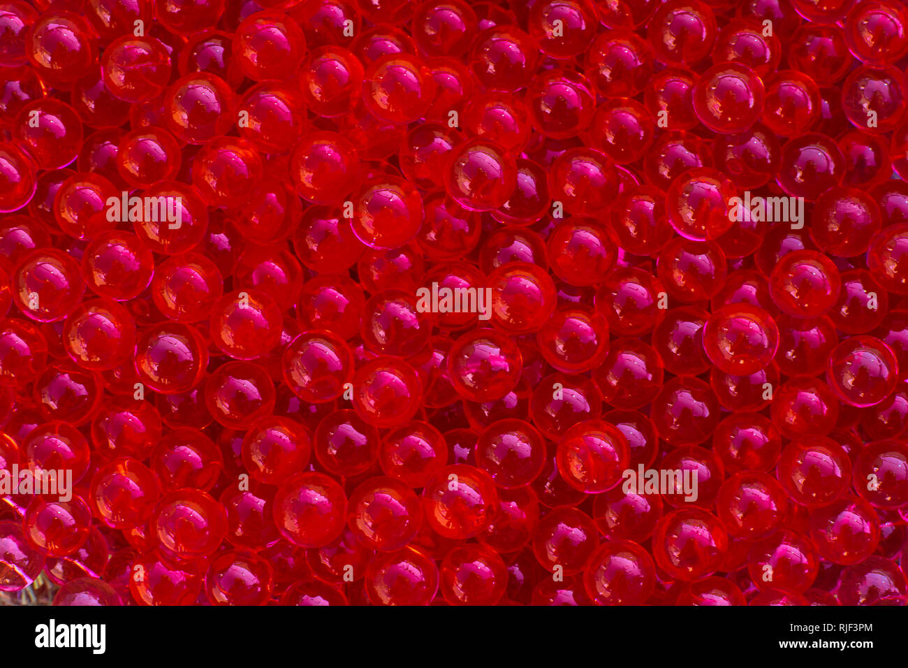 Water red gel balls with bokeh. Polymer gel. Silica gel. Balls of red
