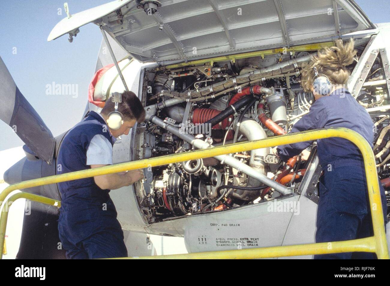 Aviation Machinist's Mate 3rd Class G. Geiger and Aviation Machinist's Mate 2nd Class Owens of Naval Air Reserve Patrol Squadron 68 (VP-68) work on the engine of a P-3B Orion aircraft.  VP-68 is in Rota for active duty training. Stock Photo