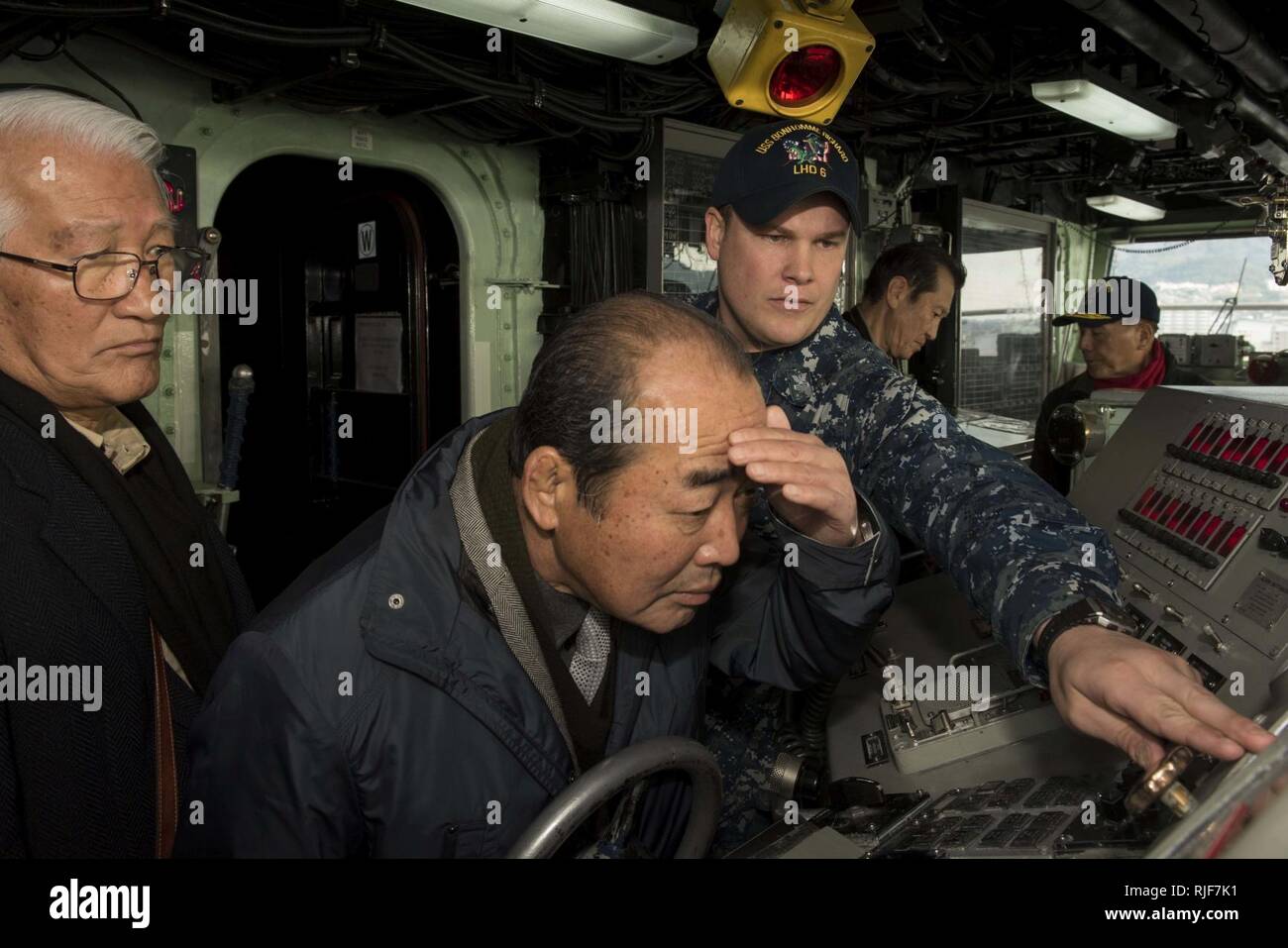 SASEBO, Japan (Jan. 18, 2017) Quartermaster 1st Class Matthew Lenerville, from Richardton, N.D., explains bridge equipment on board amphibious assault ship USS Bonhomme Richard (LHD 6) during a tour for Sasebo and Saga city community leaders. Bonhomme Richard, forward-deployed to Sasebo, Japan, is serving forward to provide a rapid-response capability in the event of a regional contingency or natural disaster. Stock Photo