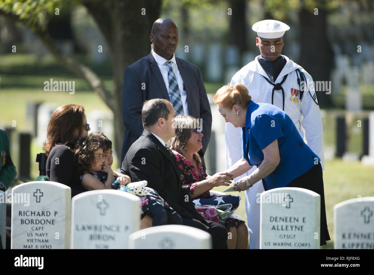 Kristin Webber-Moore receives a card of condolence from Arlington Lady Paula McKinley, right, during the graveside service for her father in Arlington National Cemetery, Sept. 22, 2016, in Arlington, Va. Her father, U.S. Navy Capt. Kent S. Webber, was buried in Section 60. Stock Photo