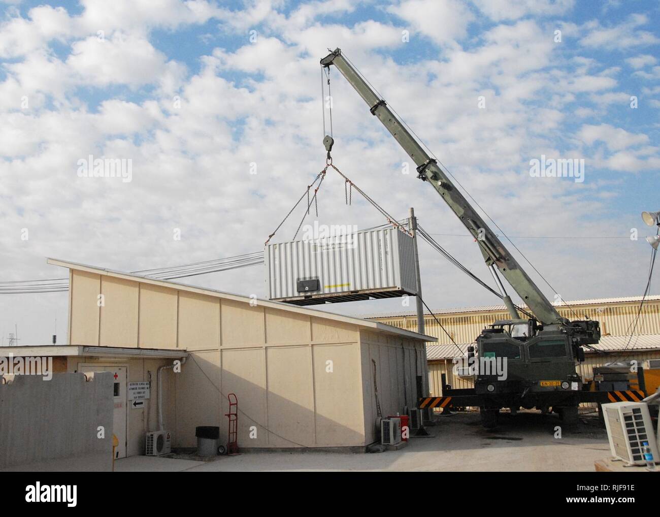 KANDAHAR, Afghanistan--A crane lifts a power supply container that was occupying the space where a new medical operation facility will be put in place at the ROLE 3 Hospital near Kandahar Air Field on February 3, 2008. The one-day project is a joint venture with the Task Forces operating in the ISAF RC South area of operation. The new operation room is expected to be fully operational later in the week. ISAF Stock Photo