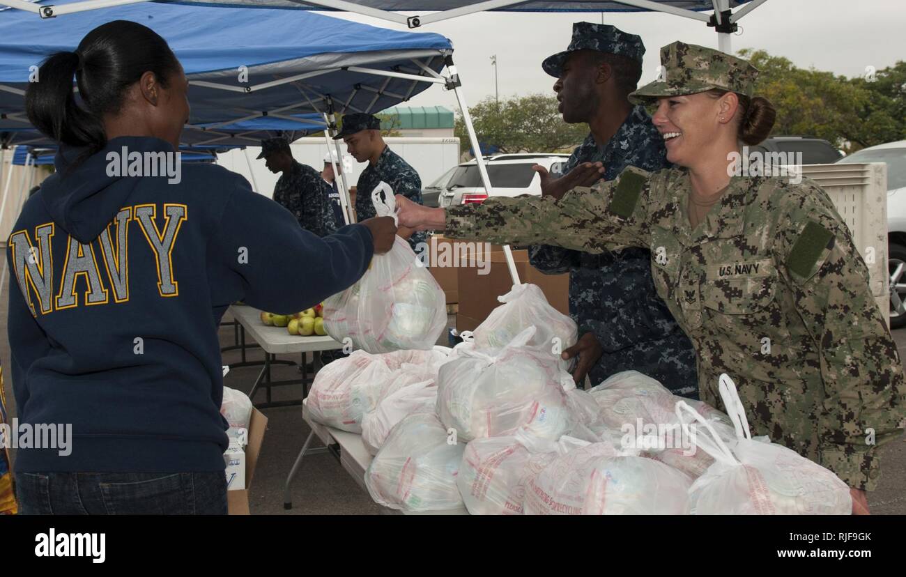 Aviation Ordnanceman 2nd Class Kimberly Rogers distributes food to families during the Neighborhood Exchange Food Bank Distribution event at the Murphy Canyon Armed Services YMCA (ASYMCA) Headquarters in San Diego. Sailors volunteered with the ASYMCA, who partnered with the San Diego Food Bank, to provide qualifying families with fresh produce and non-perishable items such as bottled juices, cereal and canned stews. Stock Photo