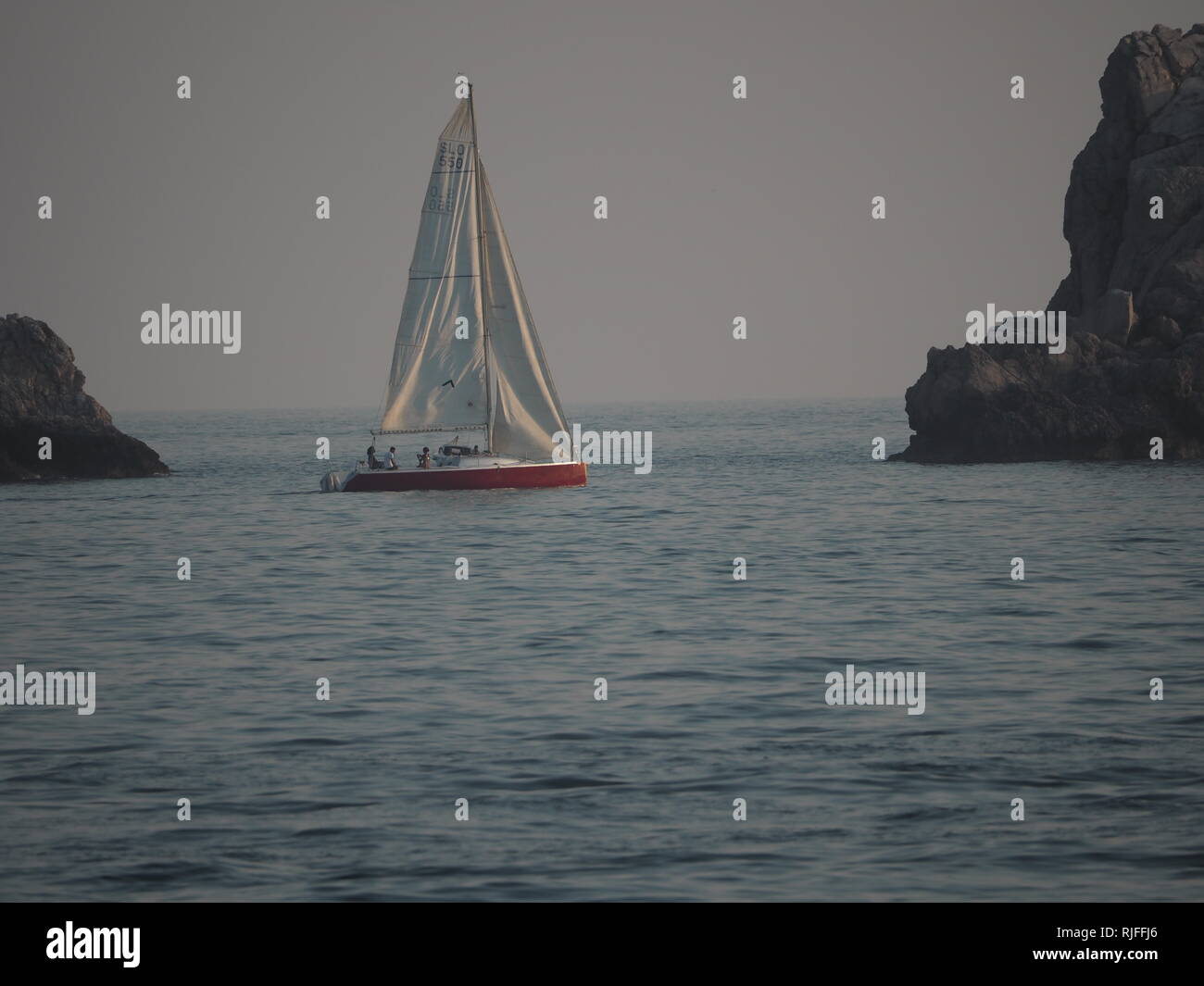 A red yacht sails on the Adriatic Sea outside Dubrovnik on a summer evening. Stock Photo