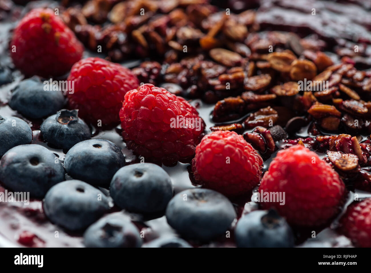 selective focus of blueberries, raspberries and homemade granola in smoothie bowl Stock Photo