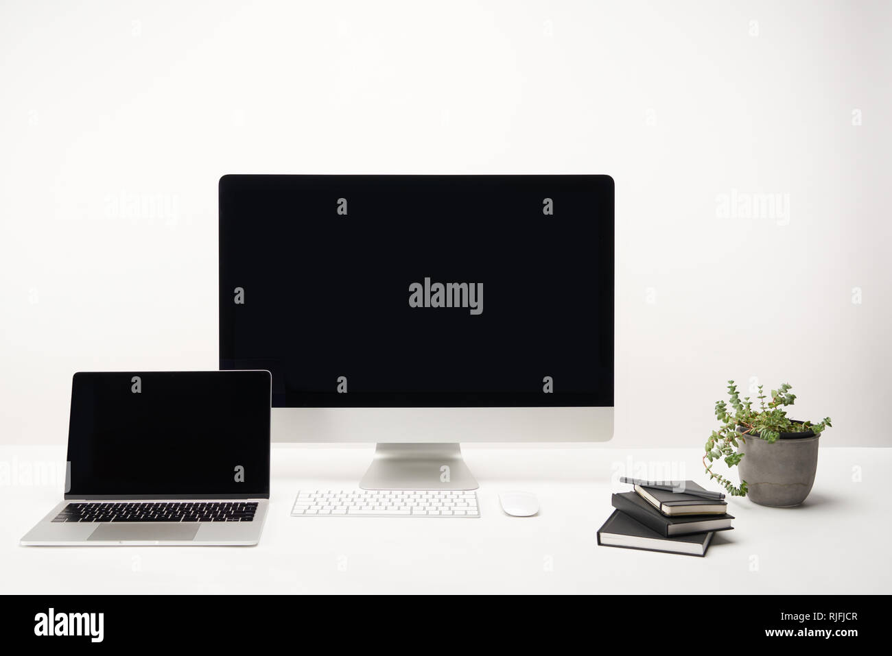 workplace with notebooks, desktop computer and laptop with copy space