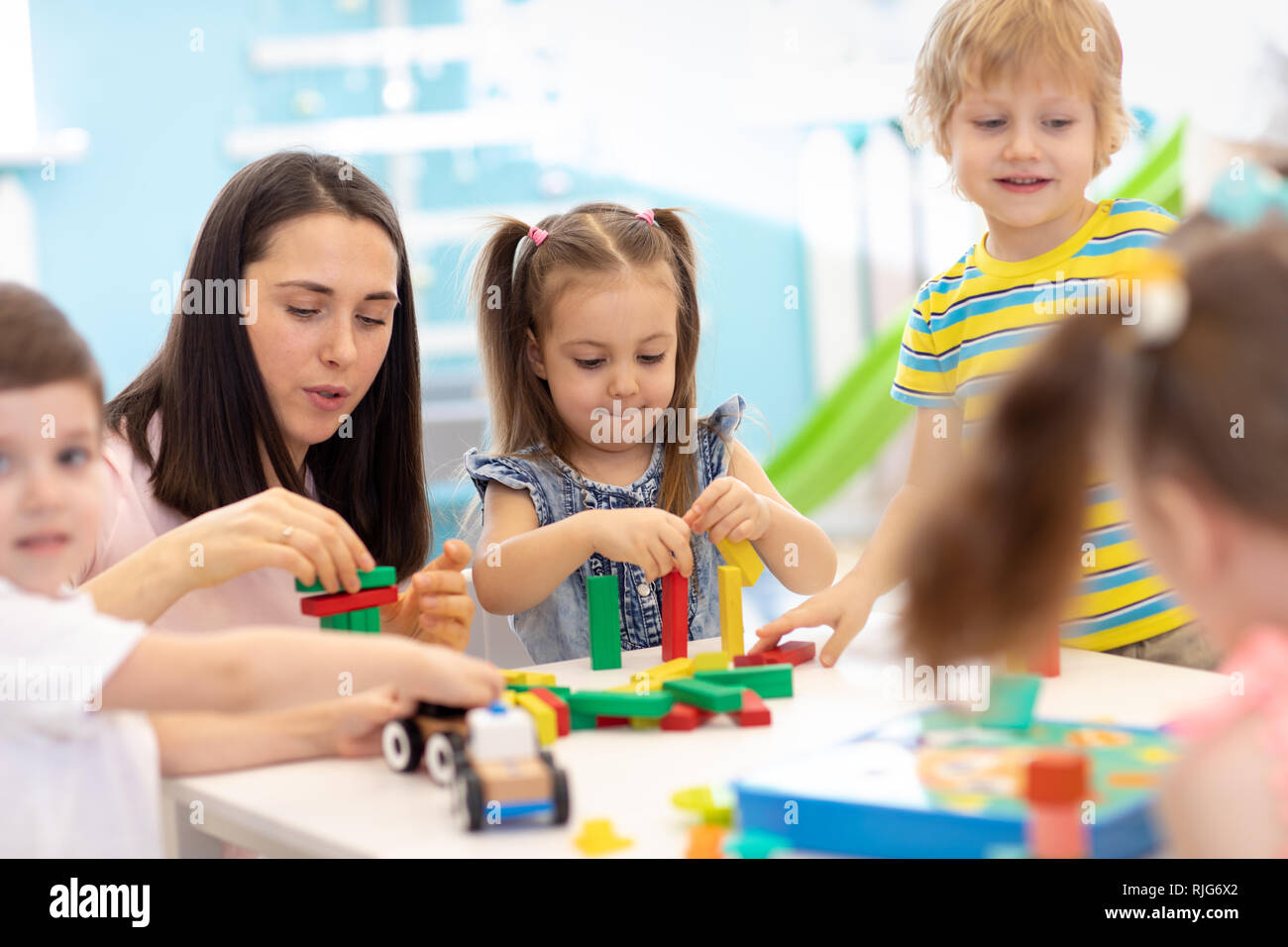 Little kids build block toys at playschool or day care center. Kids