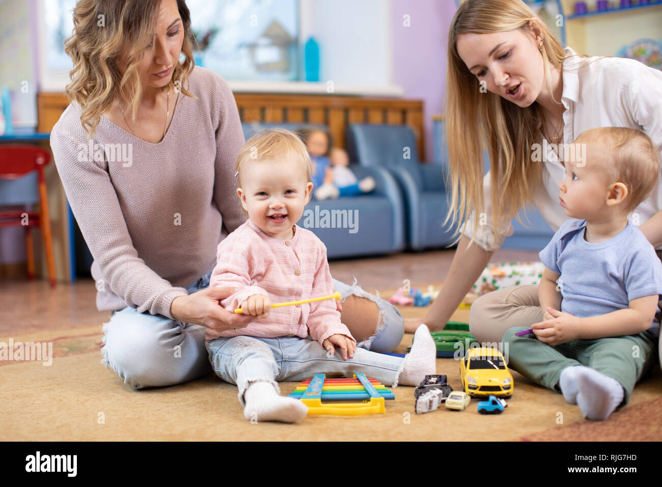Group of mothers with their babies in nursery Stock Photo