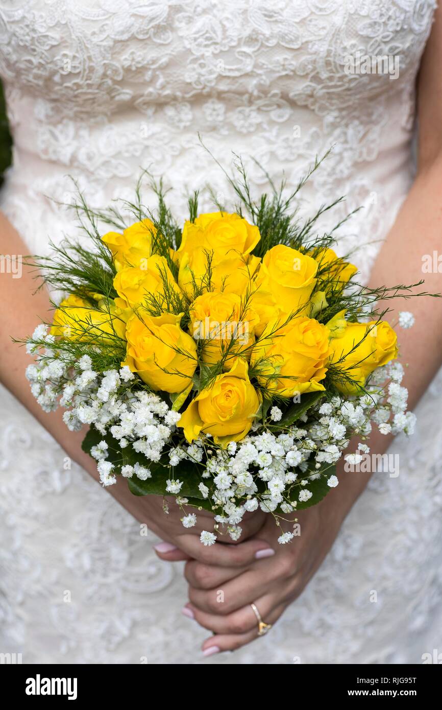 Bride holding wedding bouquet with yellow roses, Italy Stock Photo - Alamy