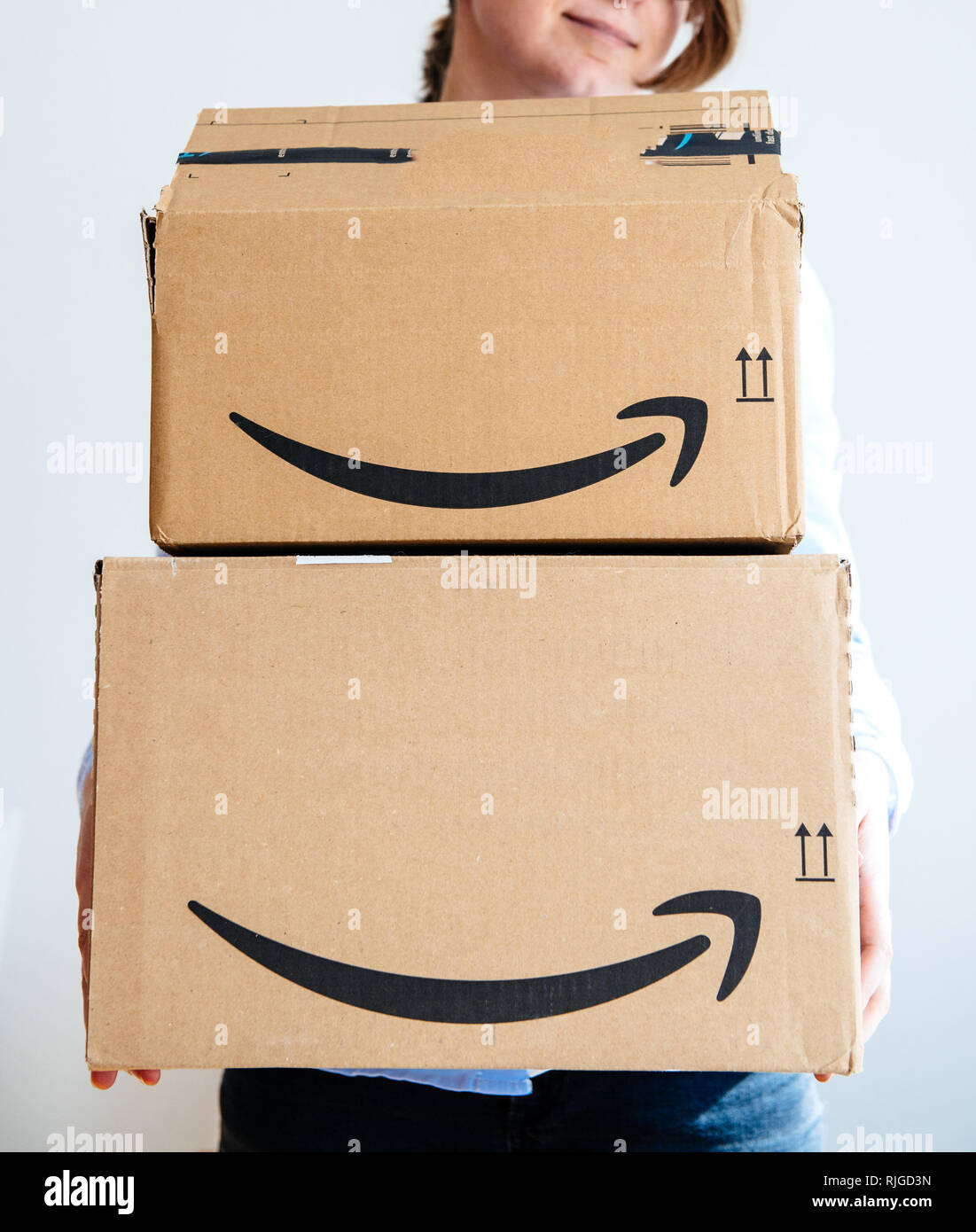 PARIS, FRANCE - MAR 16, 2018: Happy smiling woman holding two large Amazon Prime cardboard boxing after delivery - the first box is open  Stock Photo
