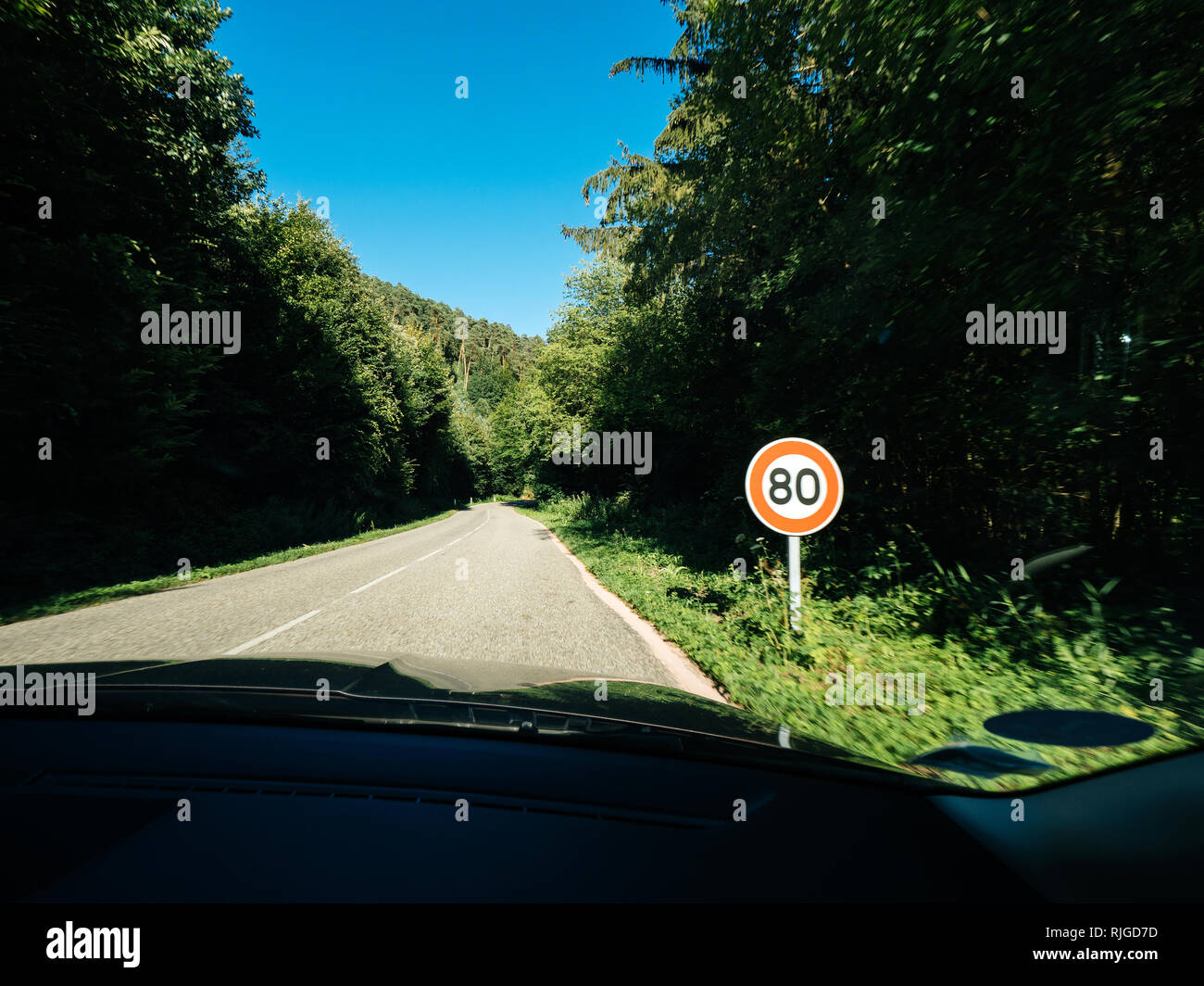 New French 80kmph speed limit sing seen on a public road in forest. As of July 1, 2018 the speed limit on two lane roads from 90 KMPH to 80 KMPH, in the hope addressing alarming rise in number of road deaths Stock Photo