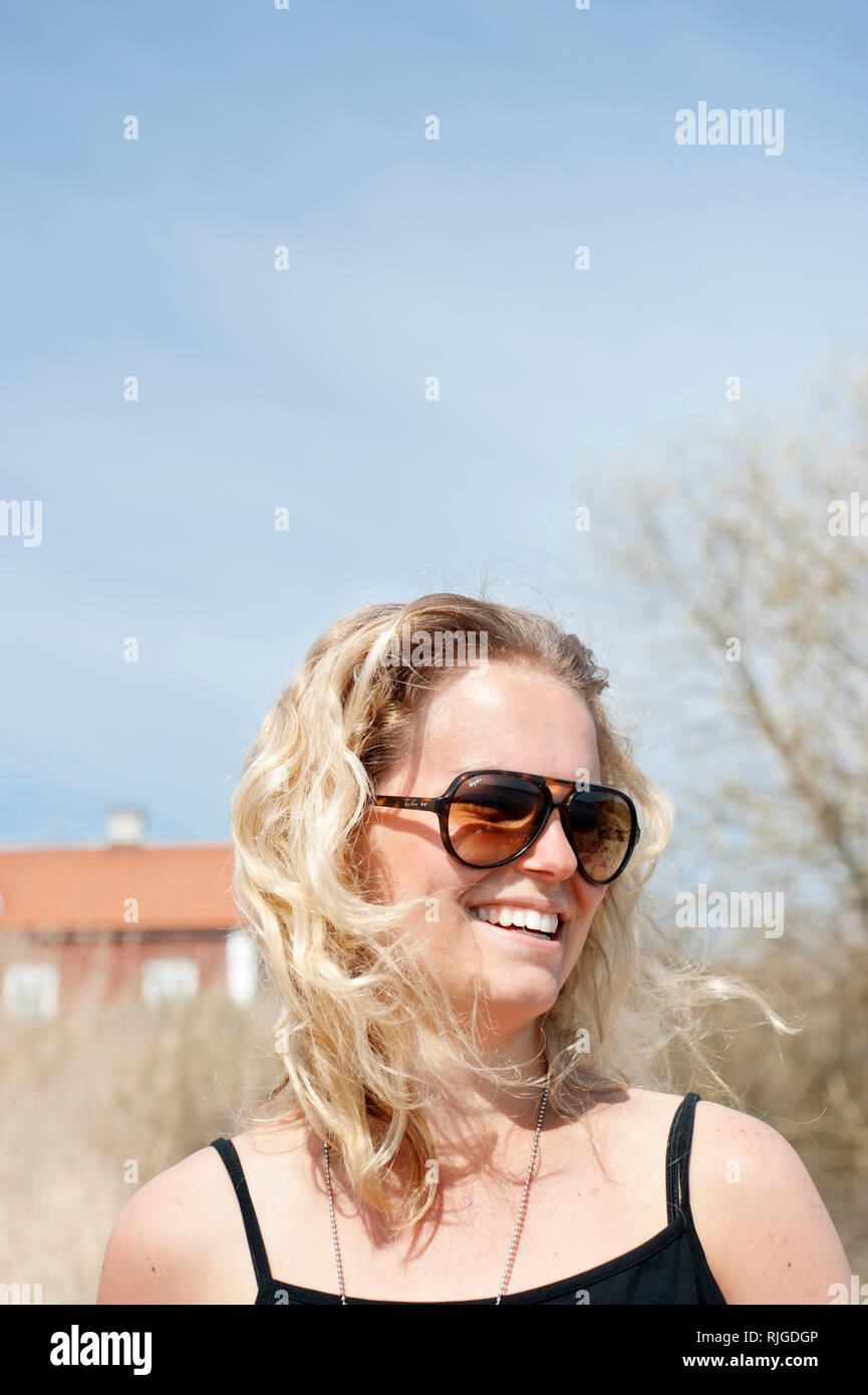 Smiling young woman with sunglasses Stock Photo