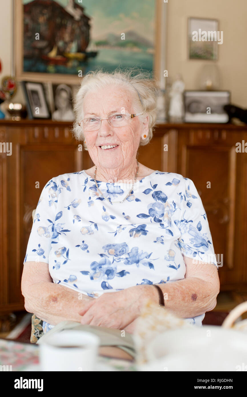 Portrait of senior woman sitting in living room Stock Photo