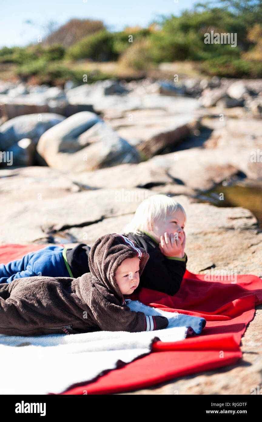 Children lying on rocks Stock Photo Alamy
