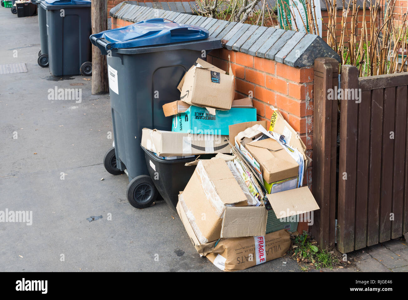 Cardboard boxes piled up beside recycling bin on the pavement during refuse collectors strike in Birmingham Stock Photo