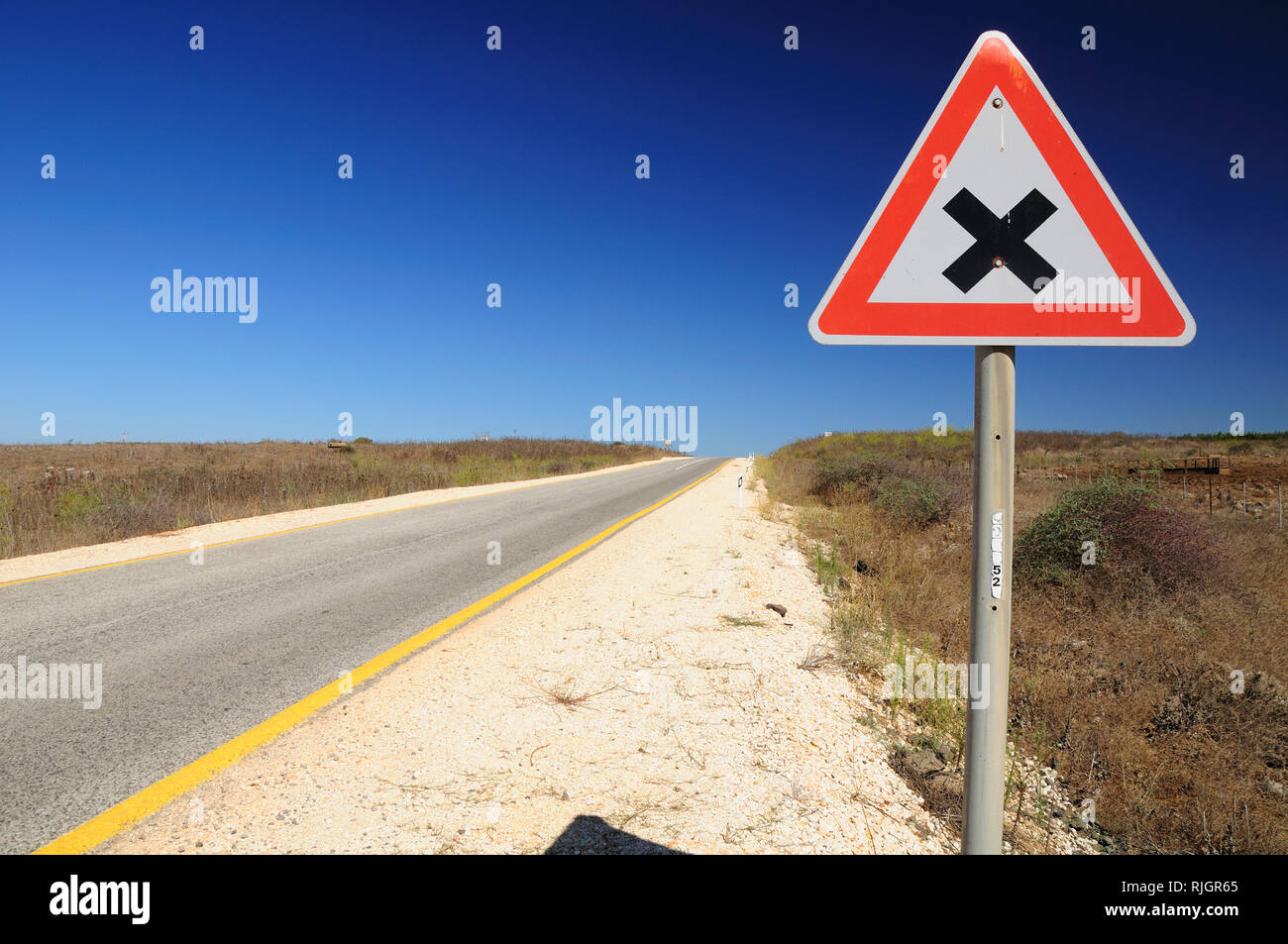 Traffic sign on Golan Heights, Israel, warning about the road intersection. Stock Photo