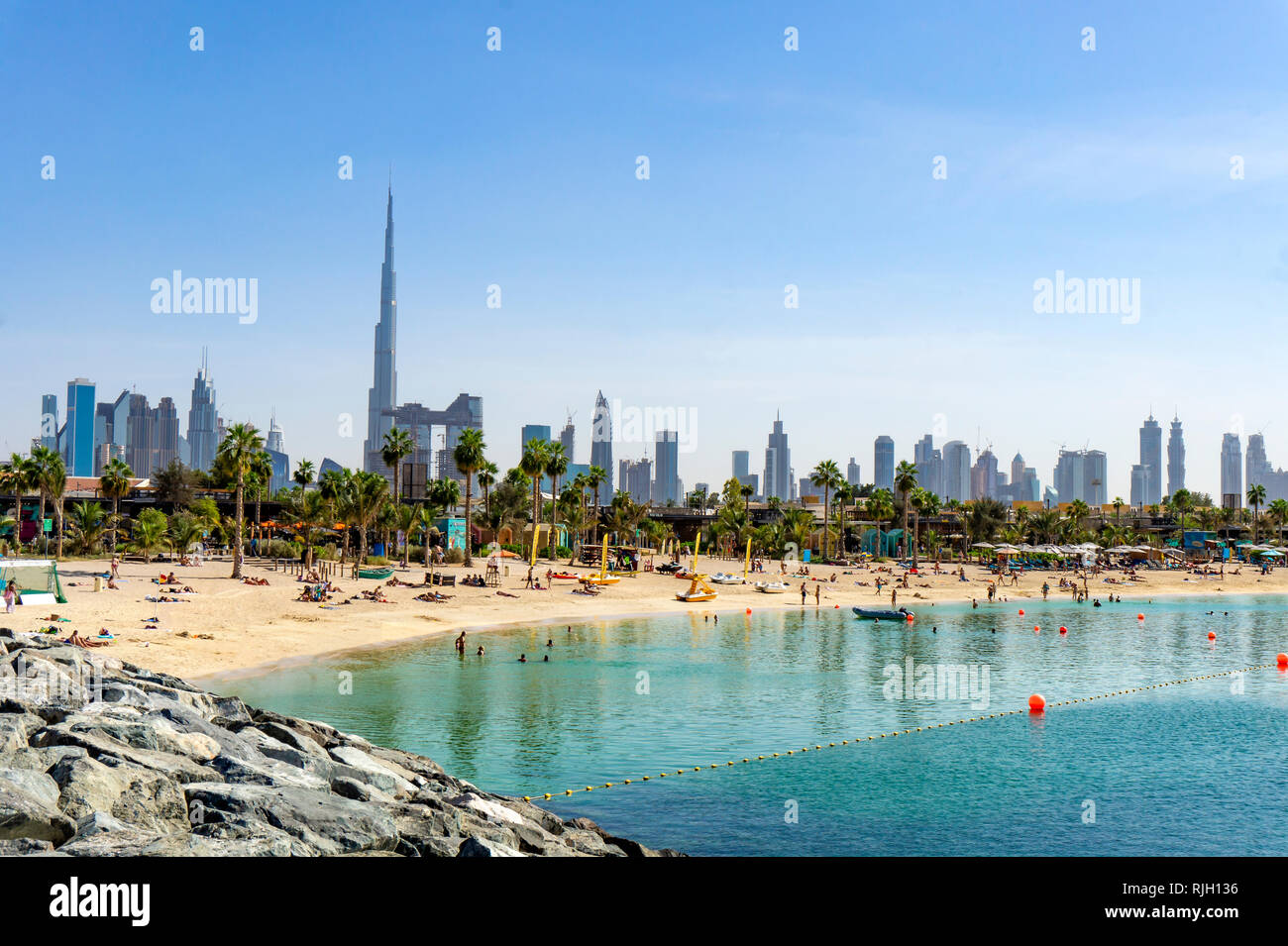 Beach in Dubai with people and skyscapers in the background Stock Photo