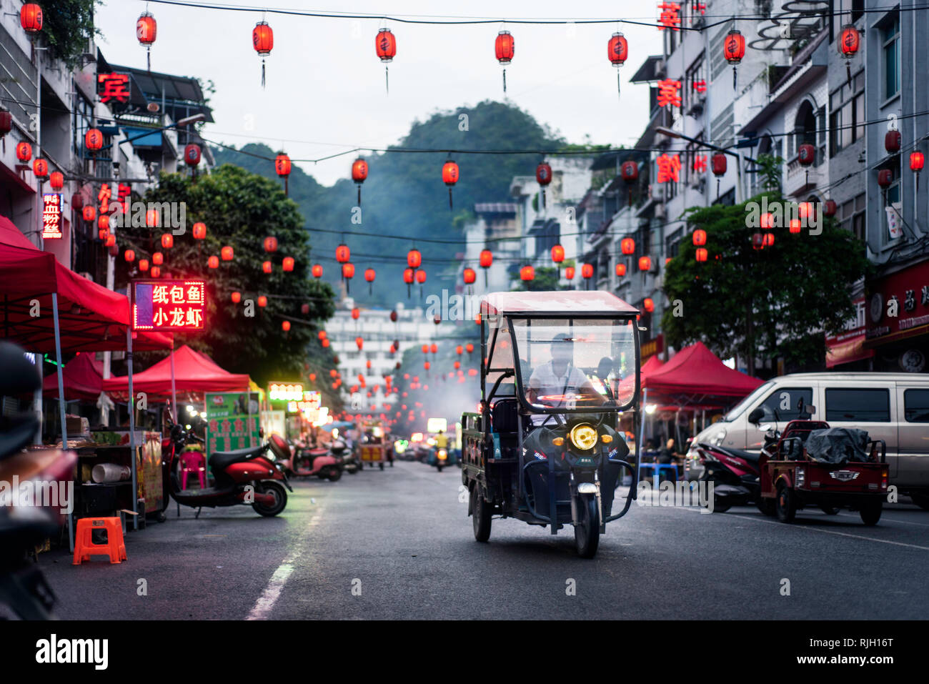Pingxiang, China - July 3, 2018: Traditional Chinese food market street scene with people preparing for the evening busy time in Guangxi province bord Stock Photo