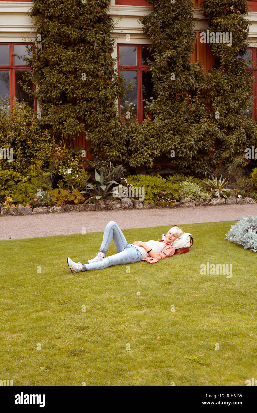 Young woman relaxing on lawn Stock Photo - Alamy