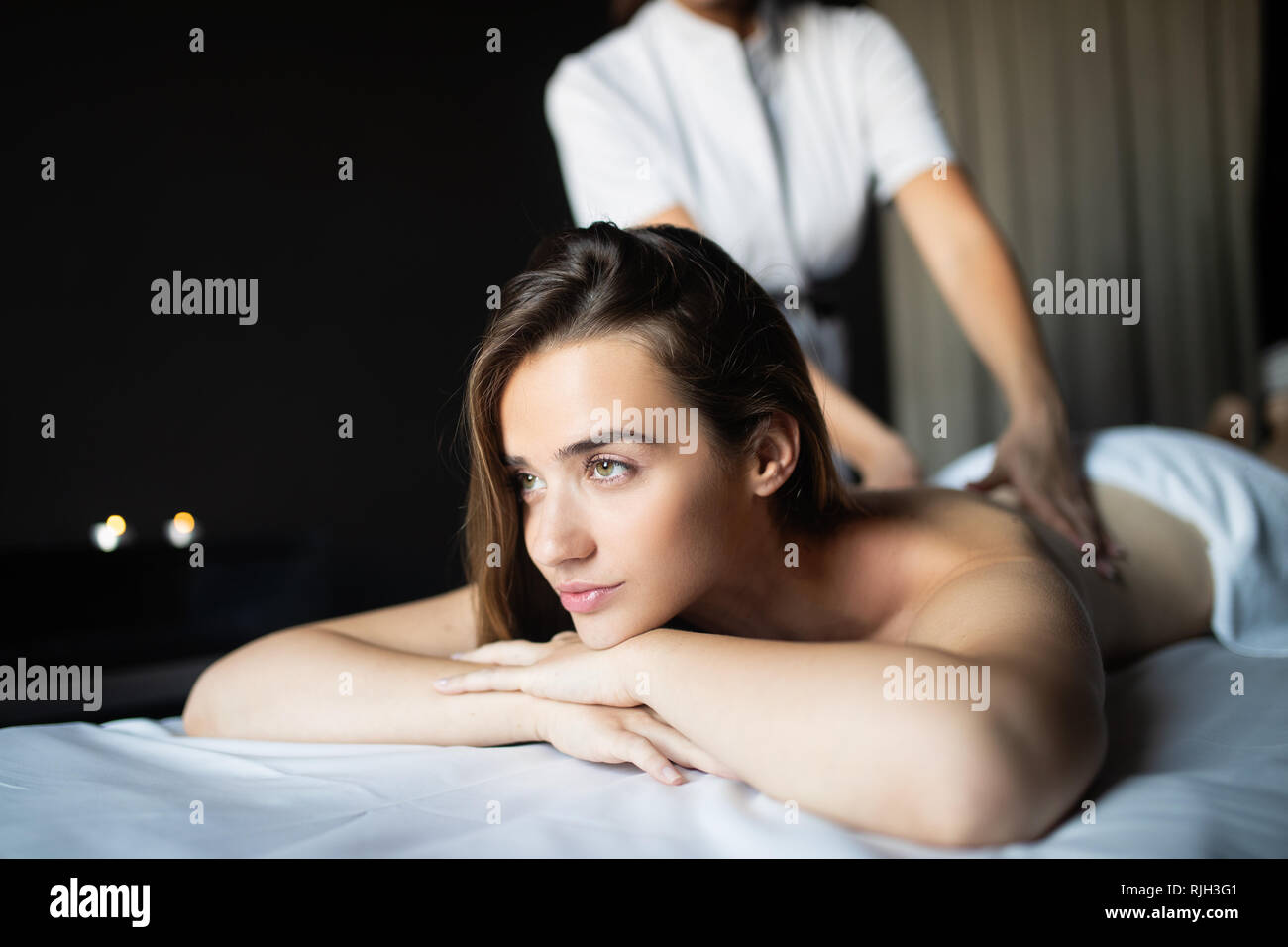 Happy woman relaxing receiving a massage in a spa salon Stock Photo