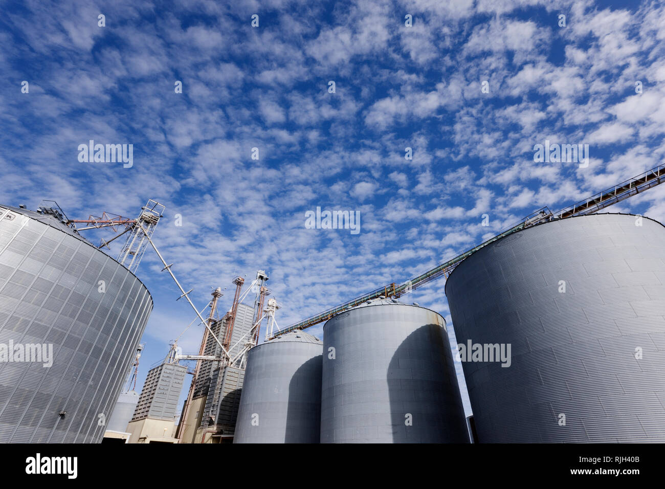 Silos against blue sky with clouds Stock Photo - Alamy